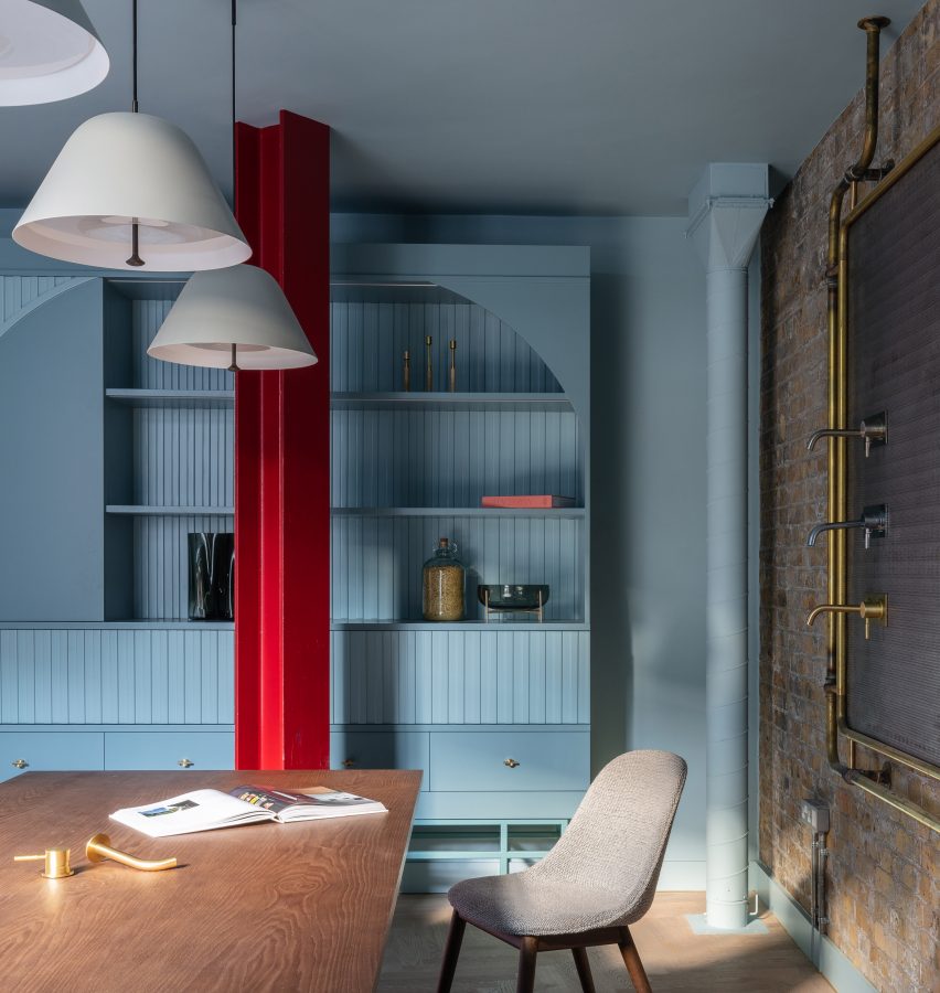 Ruang kerja bersama dengan dinding biru dan kolom merah di Boiler di lantai dasar showroom Coalbrook di London 