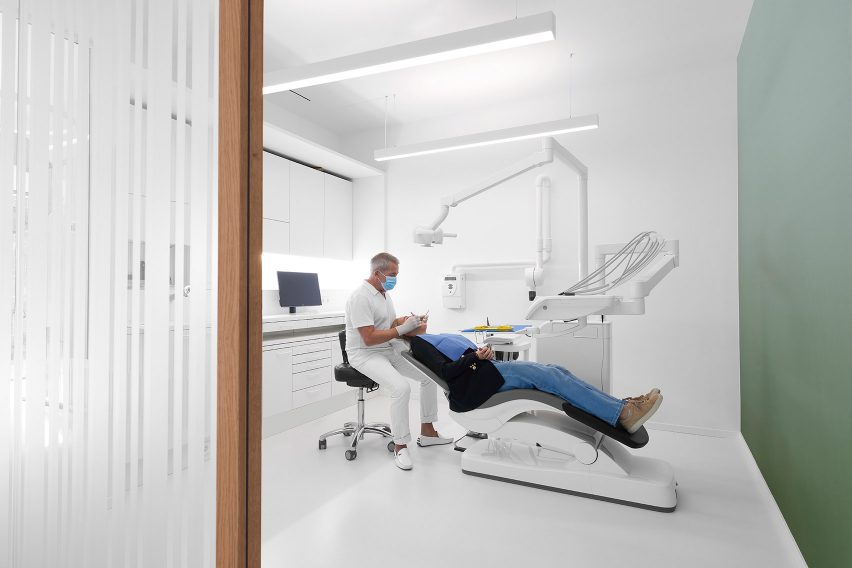 Dentist with patient in clean white treatment room by i29