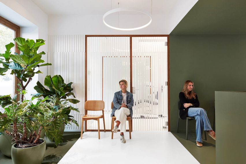 Patients waiting inside Amsterdam dentist by i29 with white and khaki-green colour-block walls