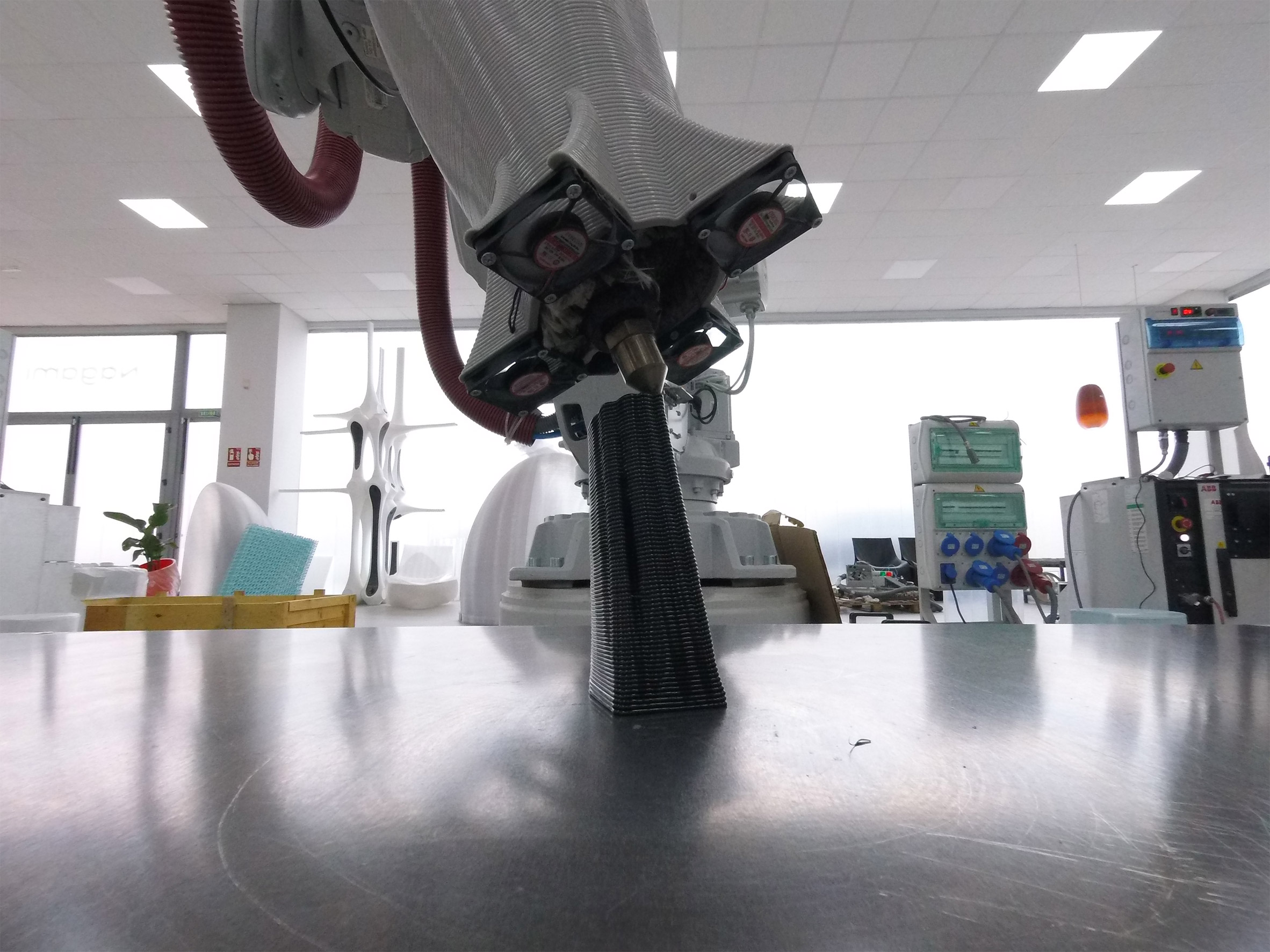 A white robotic arm printing a trophy