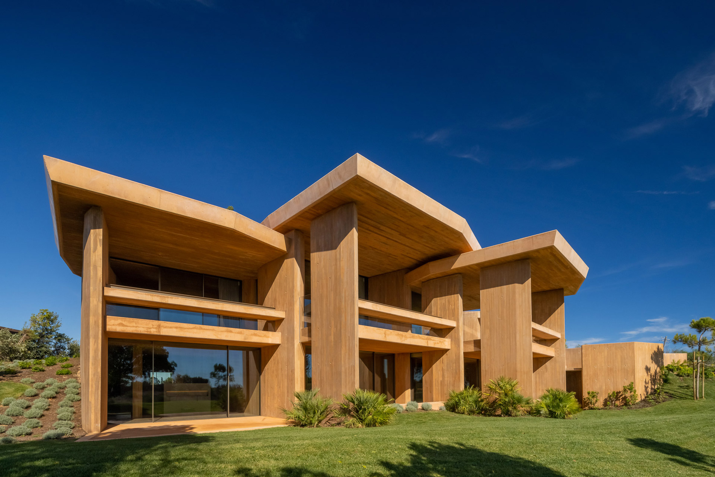 Red concrete exterior of Villa 19 at Palmares Ocean Living & Golf resort by RCR Architectes