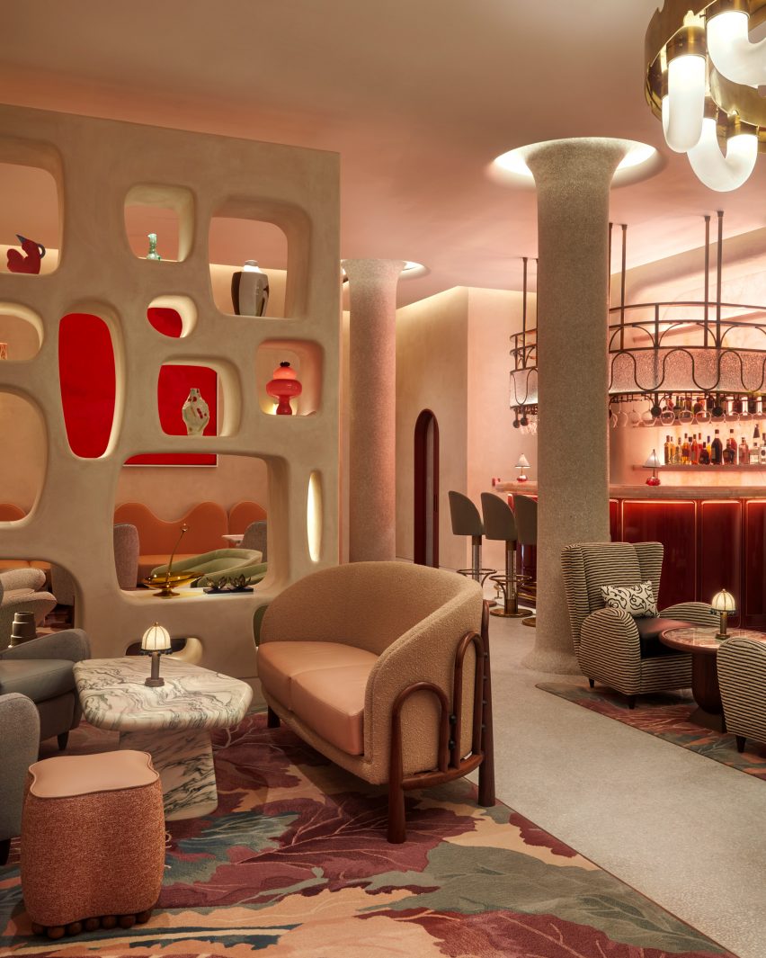 Interior of The Red Room bar with partition wall displaying ceramics and illuminated pillars surrounded by soft furnishings