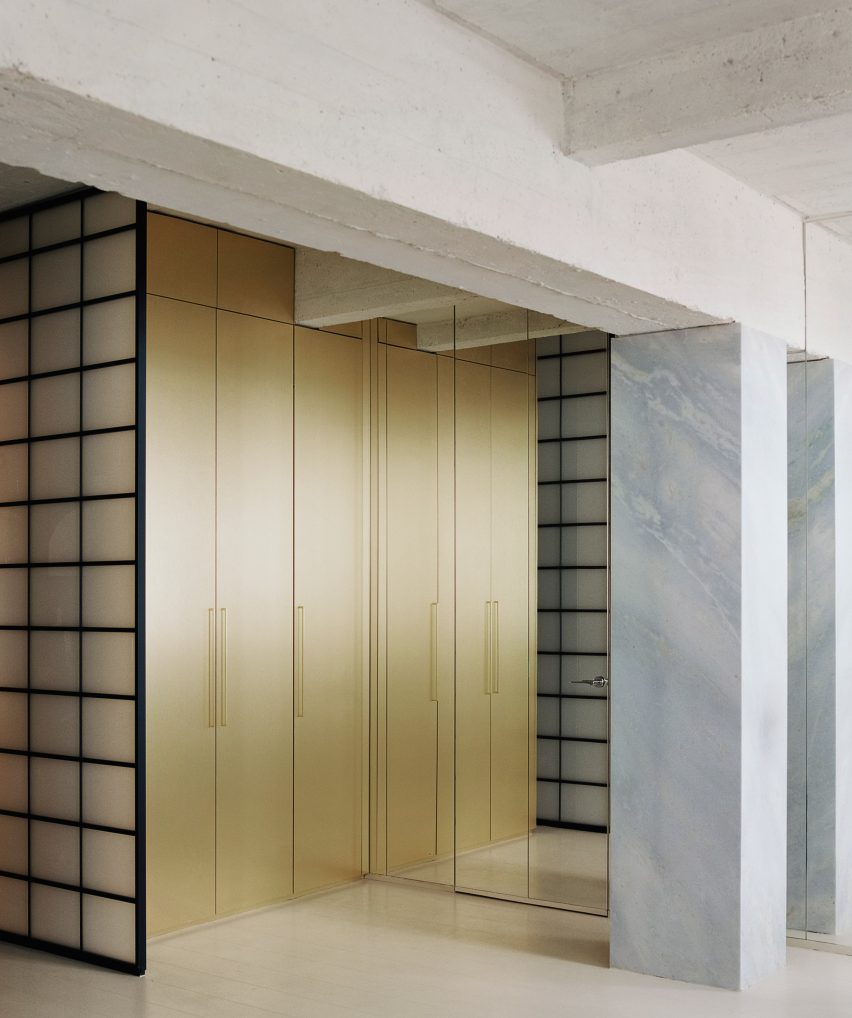 Brass wardrobe next to mirrored door and baby blue marble column in Paris flat by Clément Lesnoff-Rocard