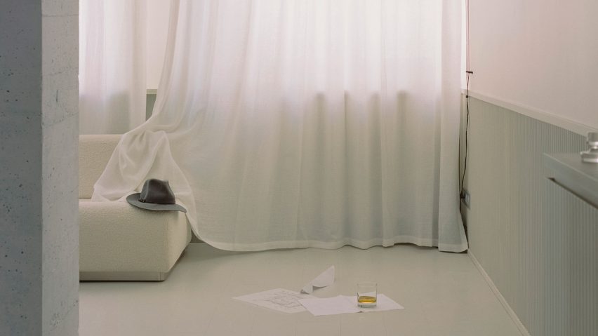 White couch with a hat and draped white curtain in interiors of The Whale apartment in Paris designed by Clément Lesnoff-Rocard