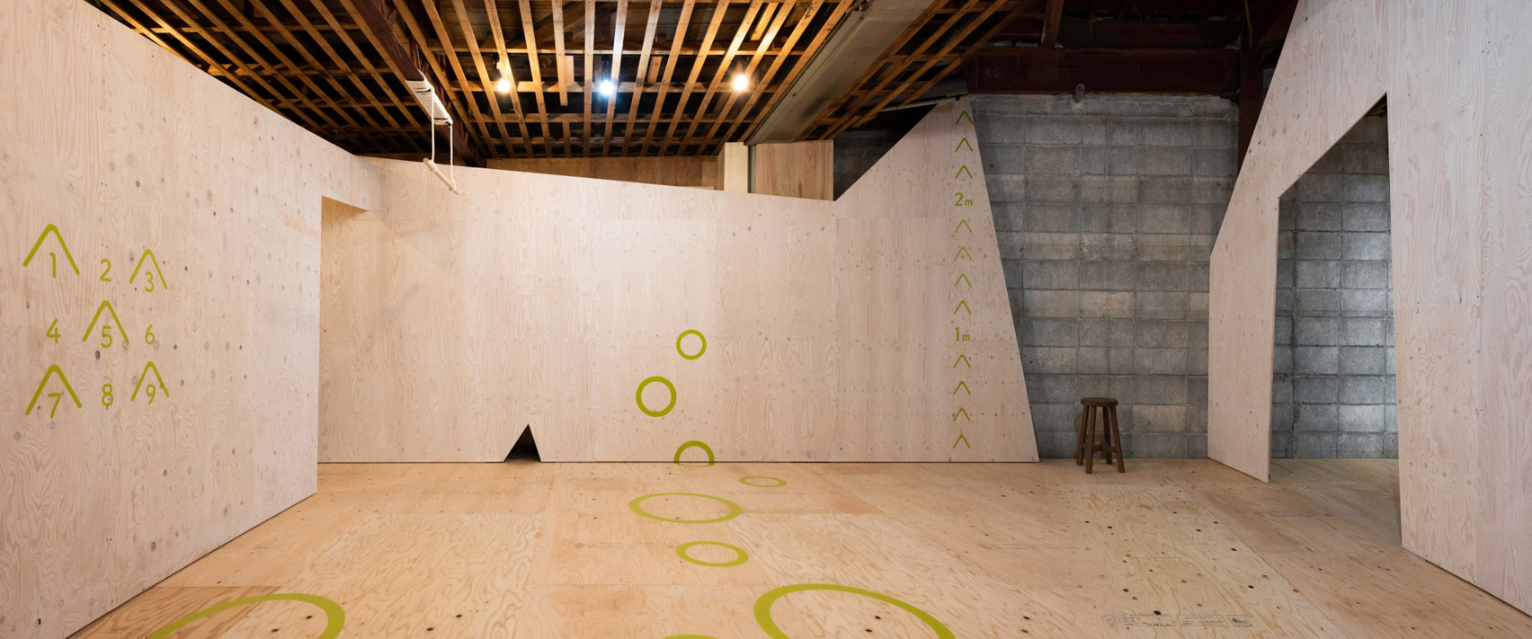 Plywood floor and walls with green markings in Yoridoko employment centre in Japan