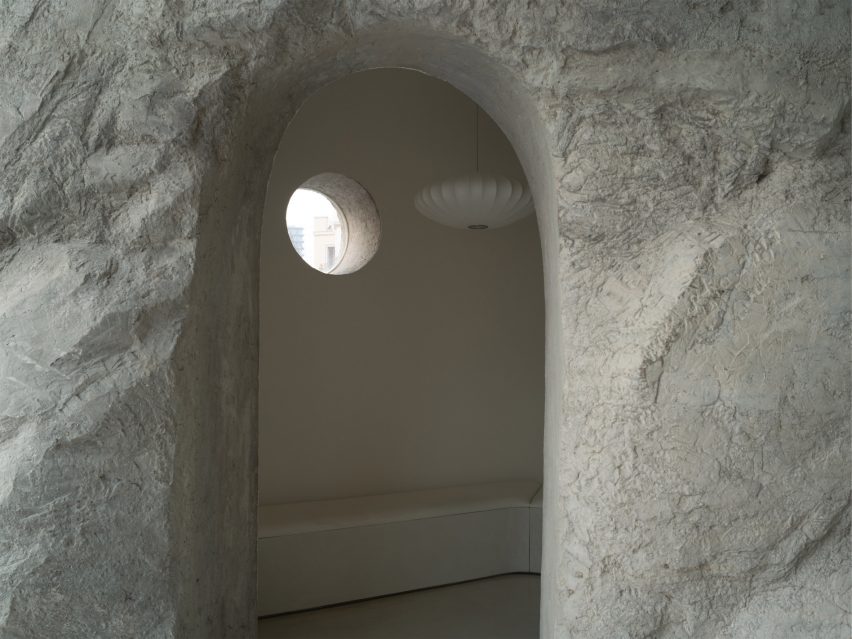 Sitting area inside a rock-like concrete column designed by BLUE Architecture Studio