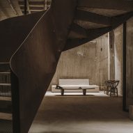 White sofa under Corten-steel staircase in 10AM Lofts event space in Athens by Studio Andrew Trotter