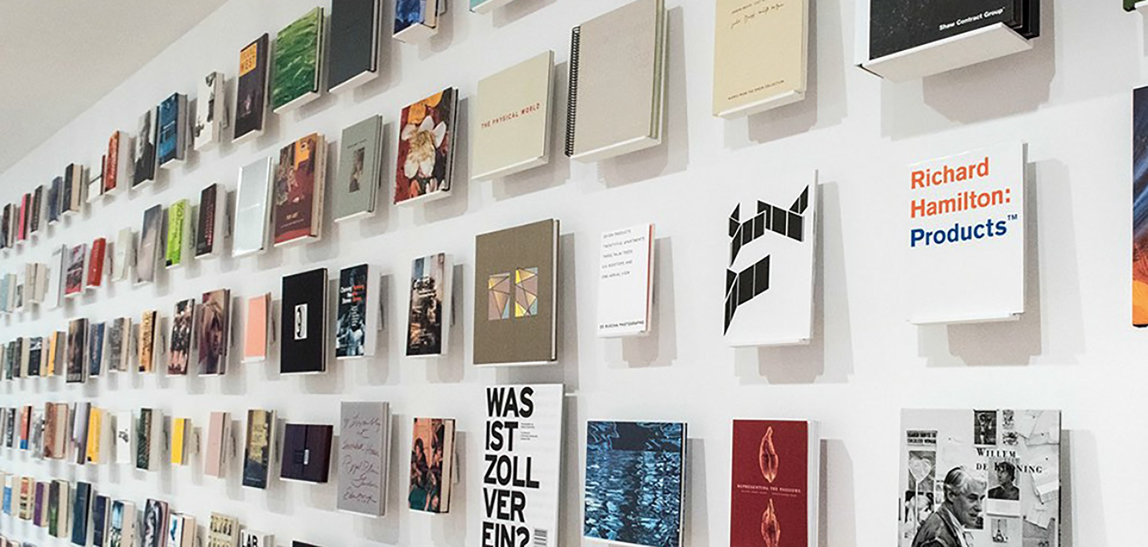 A photograph of design books displayed upon a wall