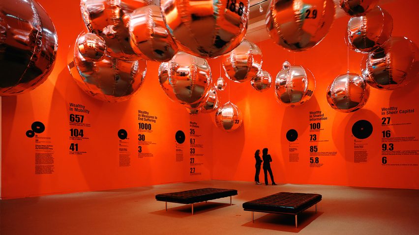 A photograph of an installation by MCN depicting a red setting with silver globe-like decorations