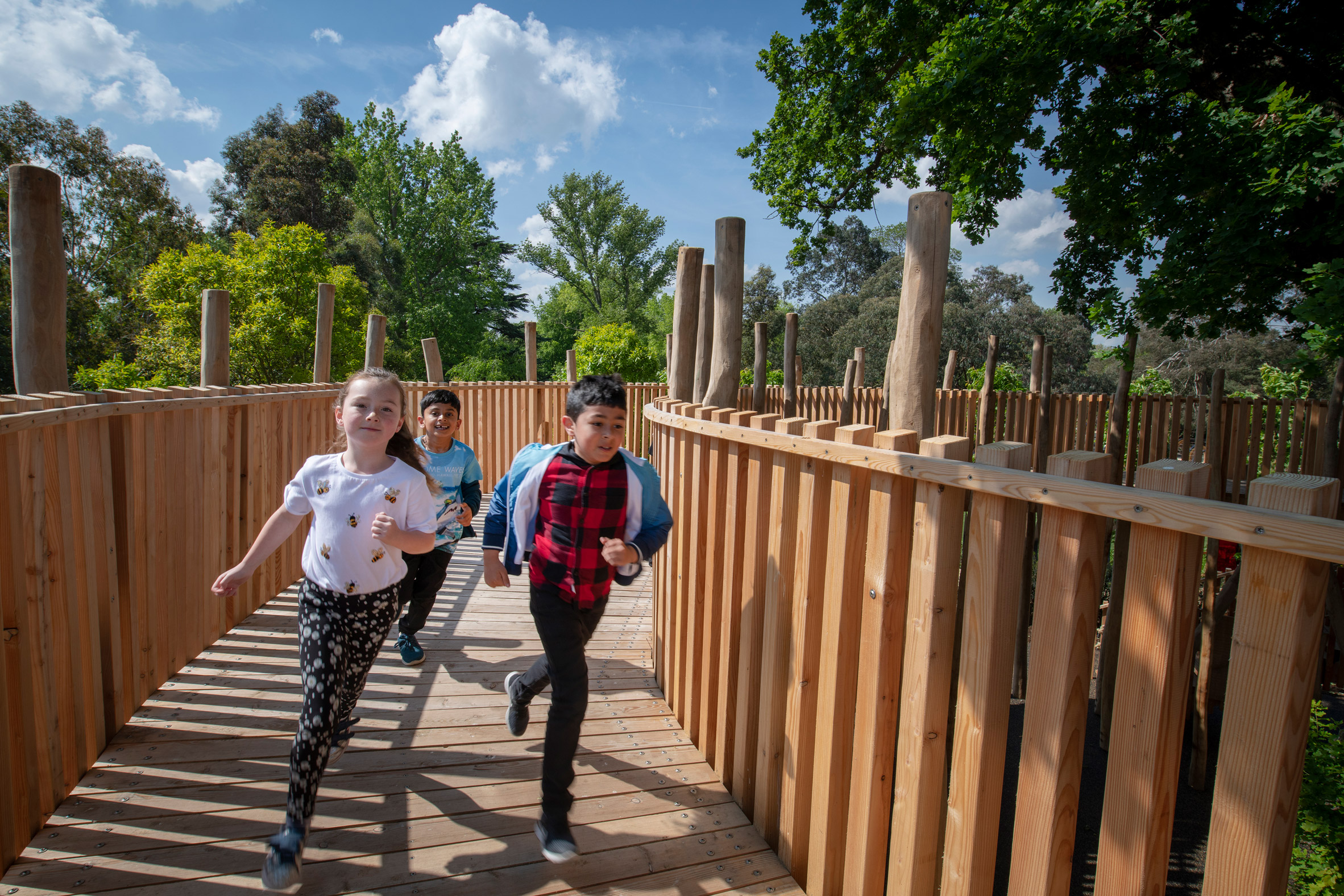 A photograph of children running around one of Kew Garden's treehouses