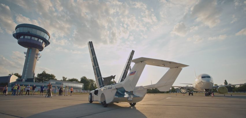 AirCar sits on the tarmac while its wings deploy from the sides of the vehicle
