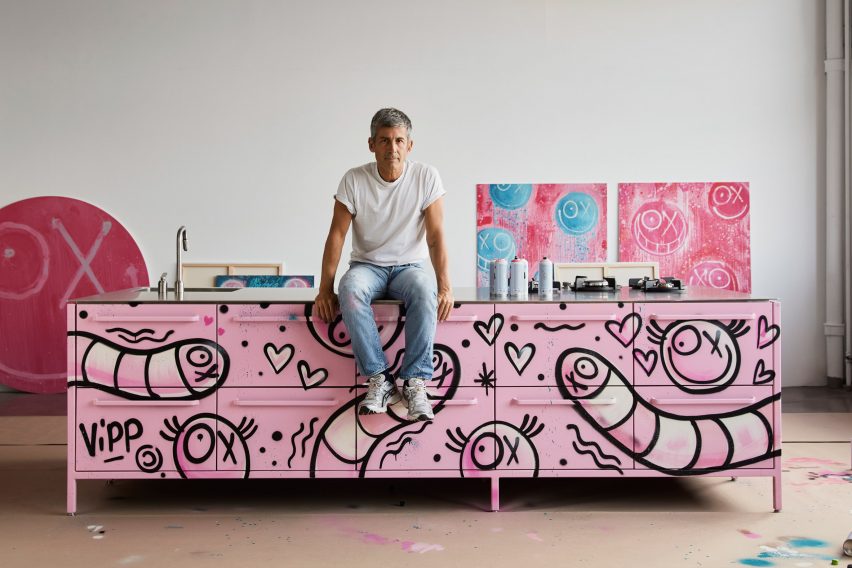 Andre Saraiva sitting on the Armour pink kitchen in the artist's studio