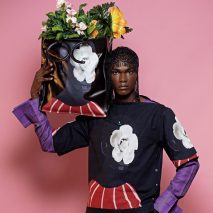 Model holding a tote bag with flowers in it from SS22 lookbook by Orange Culture, as photographed by Jolaoso Wasiu Adebayo