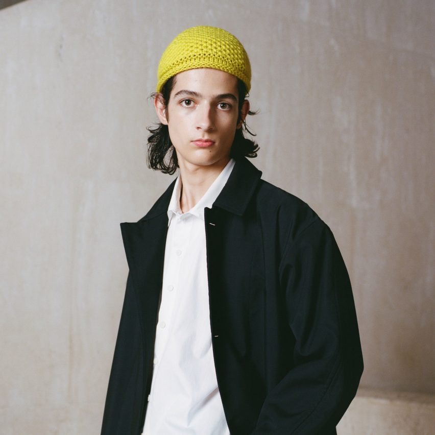 Man wearing yellow crochet hat, white shit and black jacket from the Fibershed and Phoebe English collaboration for COP26
