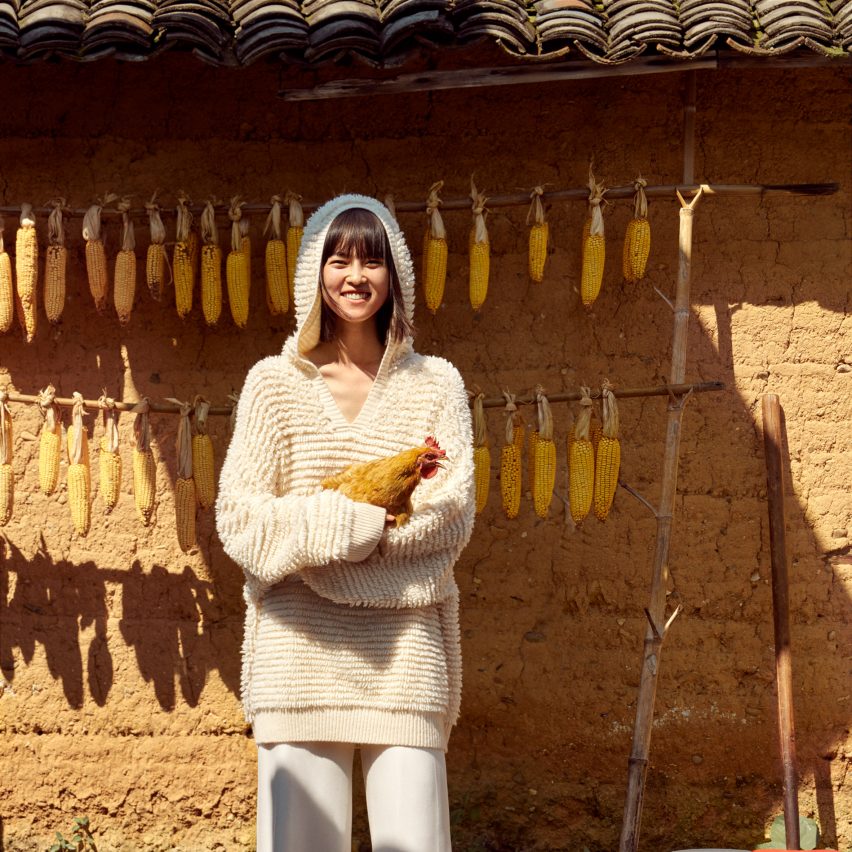 Woman holding a chicken while wearing a fluffy white cardigan from the Chinese brand Icicle