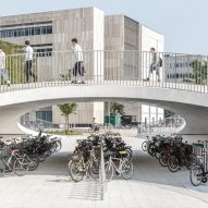 Karen Blixens Plads in Copenhagen by Cobe with bicycle storage and pedestrians passing over a bridge as photographed by Rasmus Hjortshøj illustrating EC proposal on cycling and walking infrastructure
