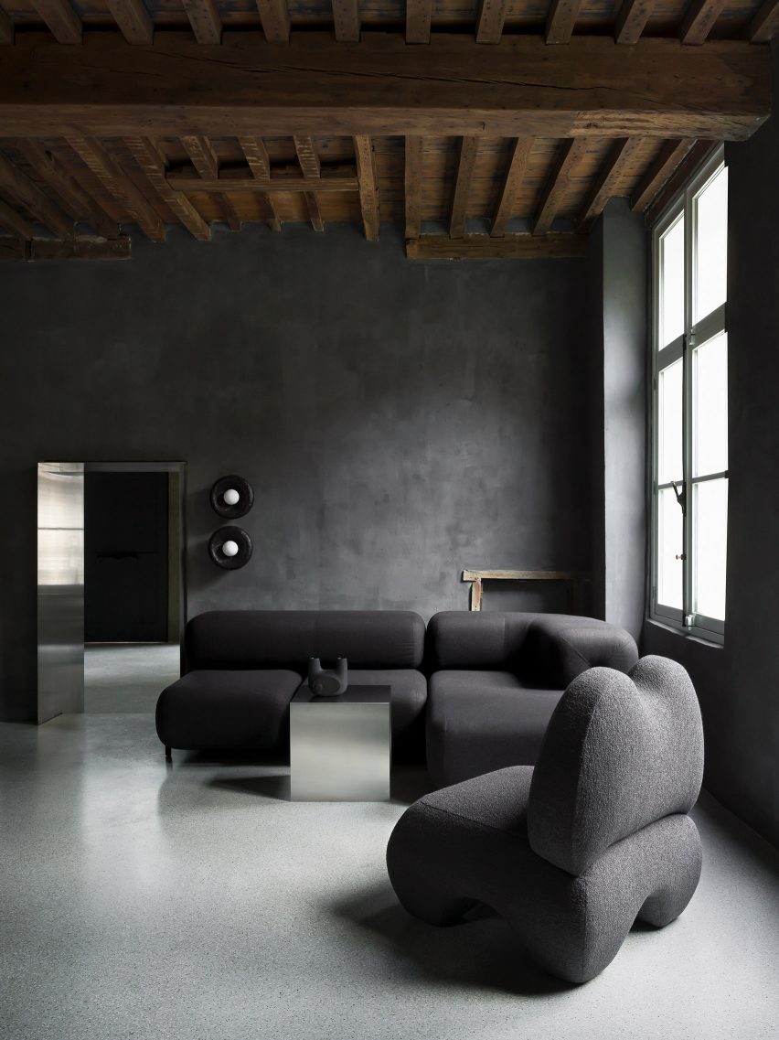 اتاق مشکی رنگ شده با مبل و صندلی راحتی مشکی توسط Faina در نمایشگاه آنتورپ توسط Yakusha Design