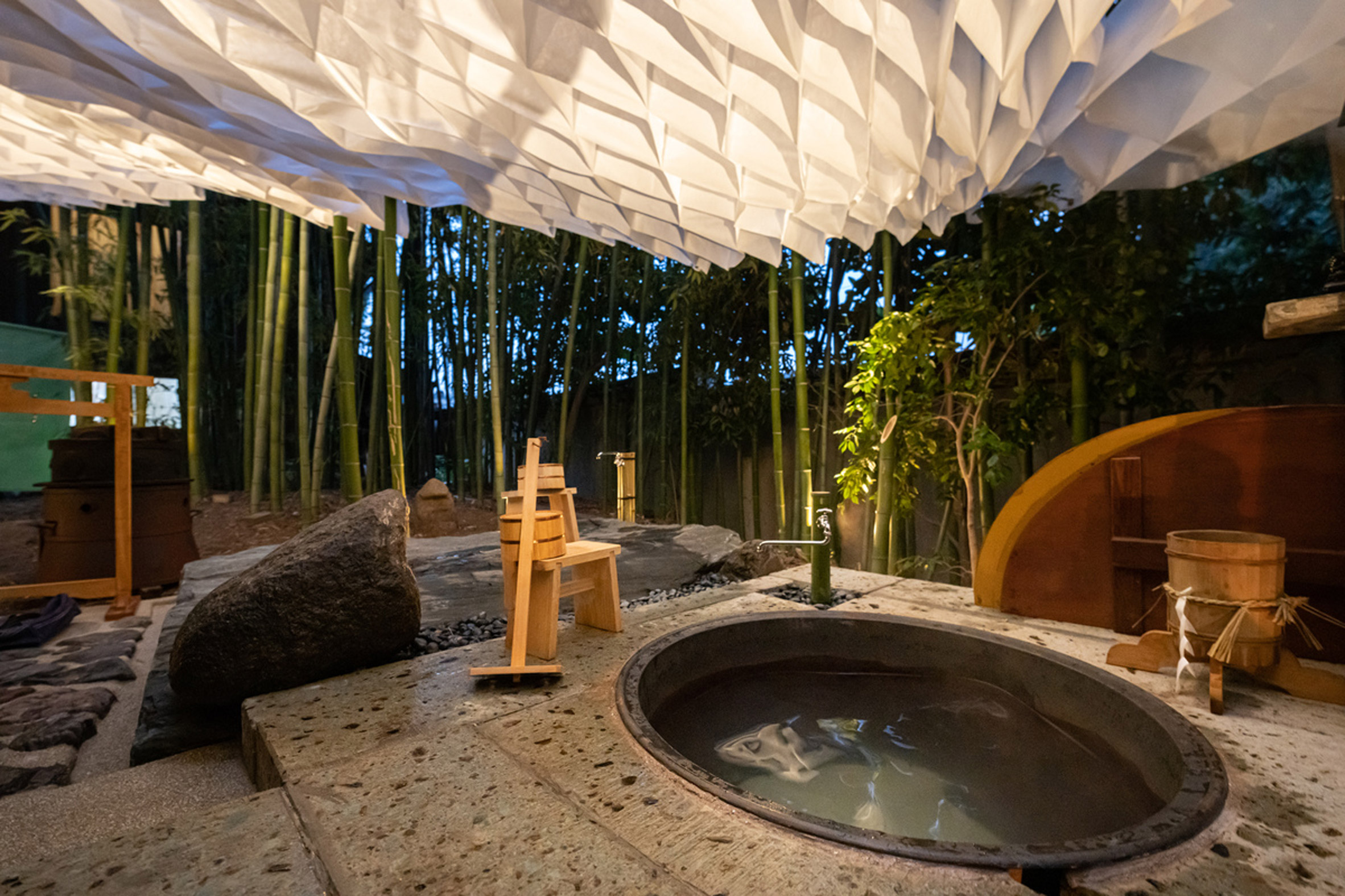 An outdoor tub is pictured beneath the fabric pavilion