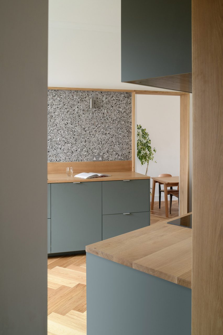 Sage-coloured IKEA kitchen with terrazzo backsplash and oak counters in Leith apartment