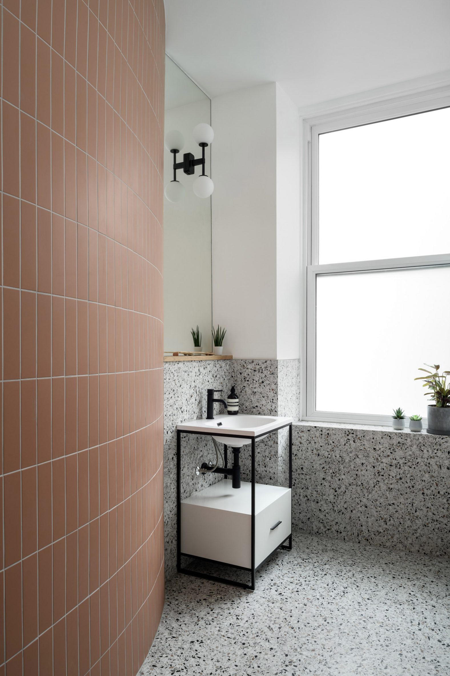 Freestanding sink with integrated cabinet in terracotta and terrazzo panelled bathroom designed by Luke McClelland