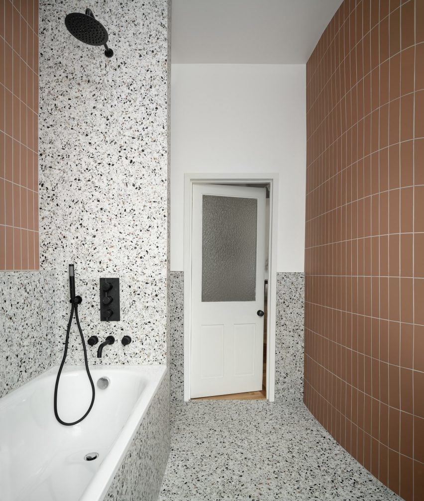 Bathroom of flat in Leith with curved terracotta-tiled wall and terrazzo backsplash