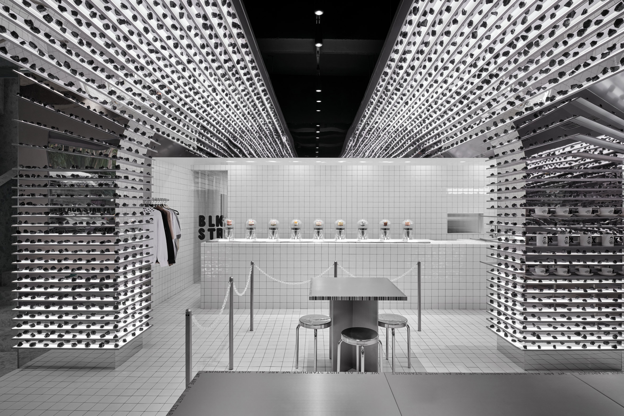 Bakery interior with curved silver walls, white floors and silver tables and chairs