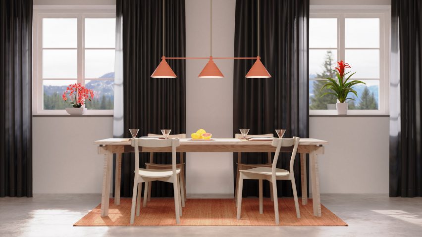 Orange pendant light with three conical shades in a line hung above a dining table