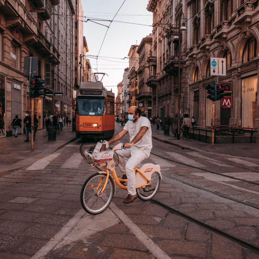 Homme faisant du vélo devant un tramway à Milan, illustrant un reportage sur le projet de réseau cyclable Cambio à Milan