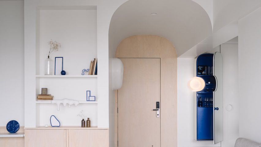 Wooden door in rounded-off entryway of Out of the Blue apartment in India by The Act of Quad