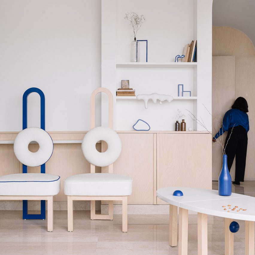 Matching chairs in cobalt-blue and nattural wood with circular cushions in living room of Out of the Blue apartment in India by The Act of Quad