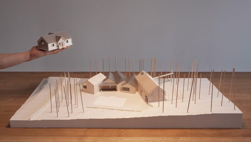Architectural model of the Polish Farmhouse showing five intersecting barn-like volumes surrounded by sticks representing a forest