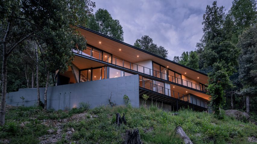 A house perches on a hill in a Chilean forest