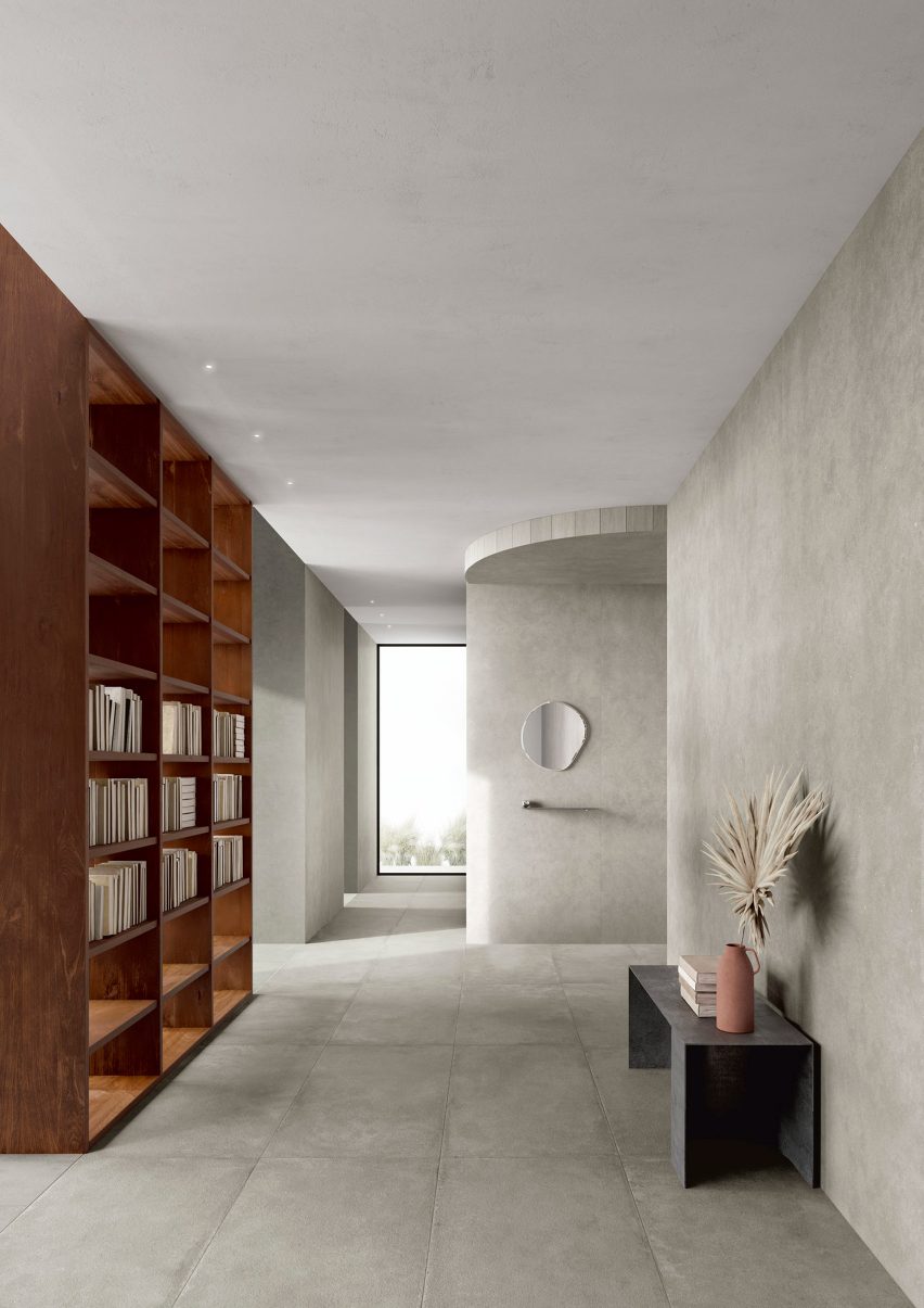 Hallway with bookshelf and low console tiled in Roc Gris tiles