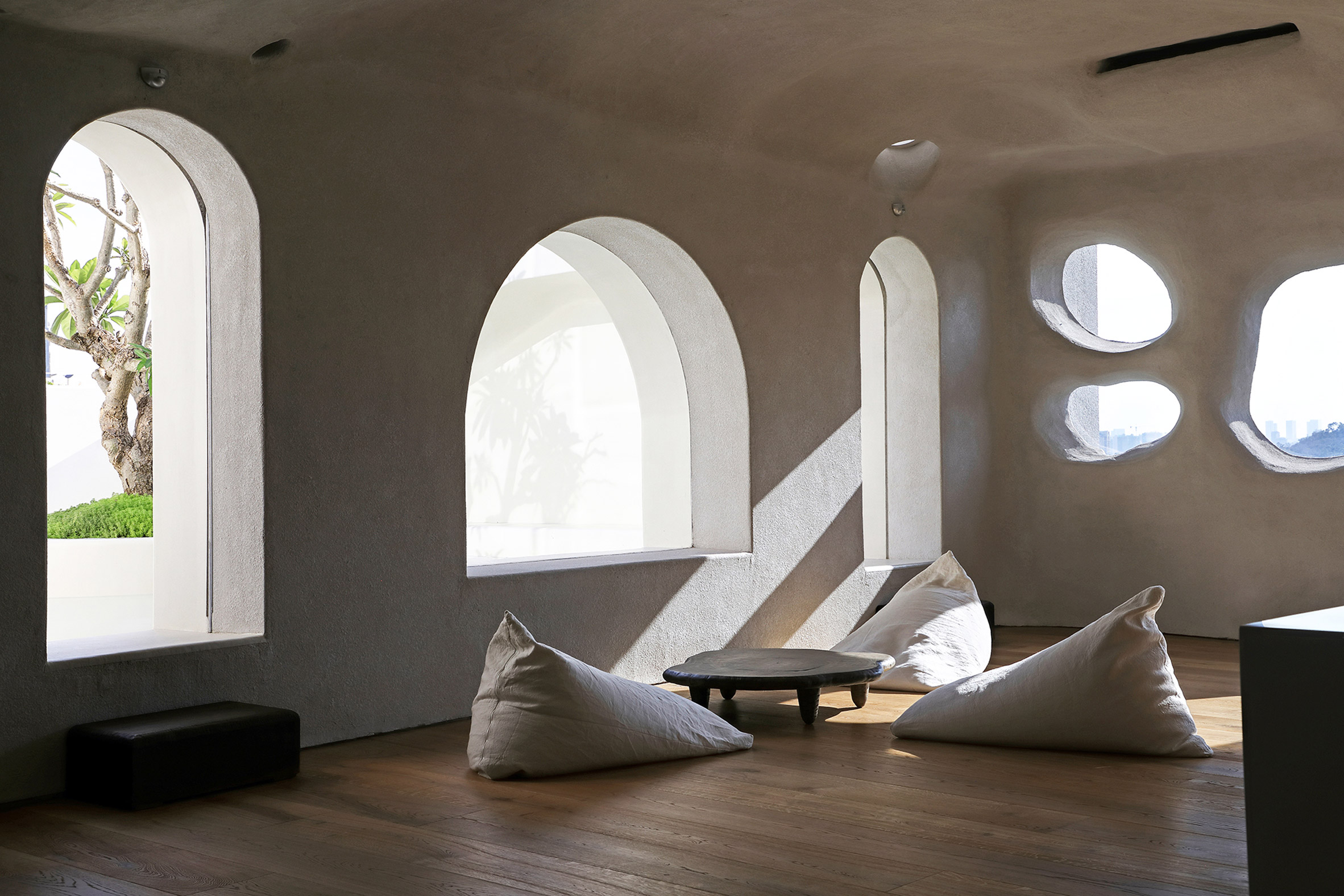 White beanbags on wooden floor of Xiamen gym by Wanmu Shazi next to arched windows