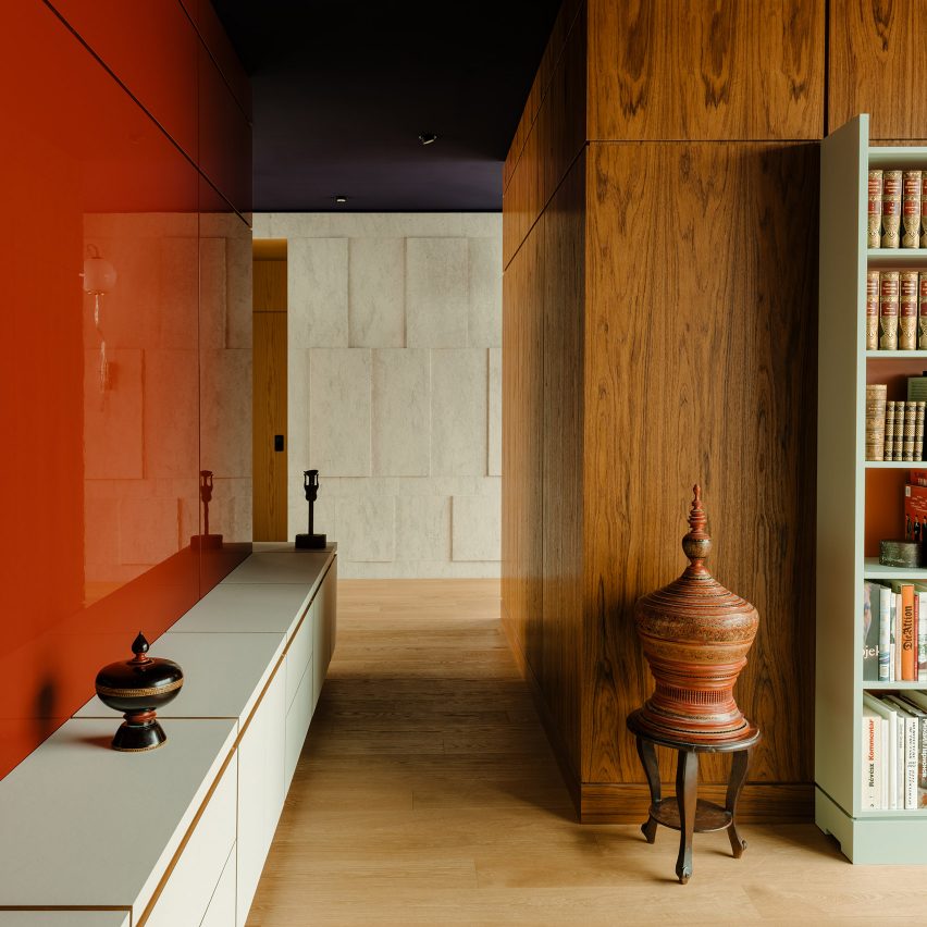 Walls clad in teak, red-lacquered wood and limestone in interior of Berlin apartment The Village designed by Gisbert Pöppler