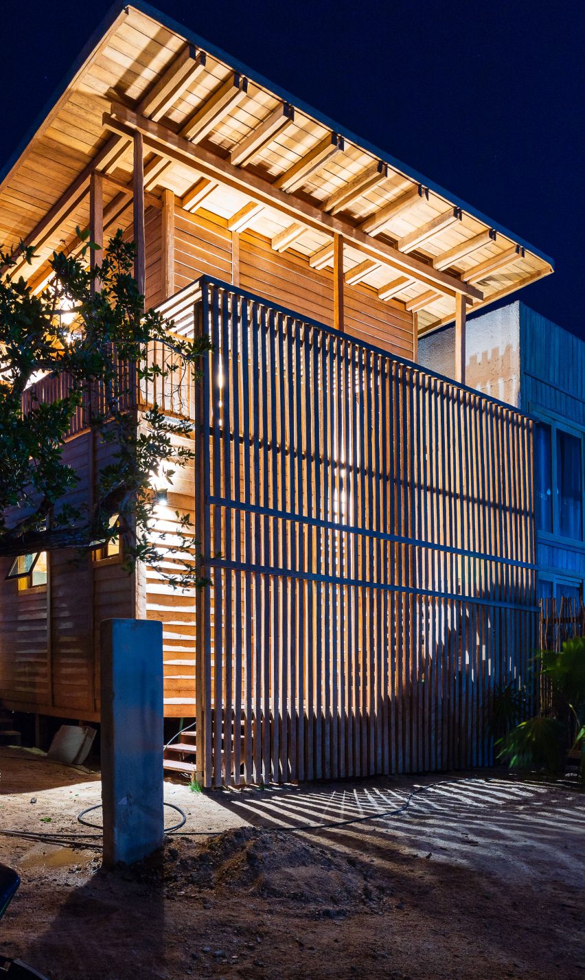 Casa Numa at night with exterior coconut palm timber screen partially blocking the warm light coming from inside
