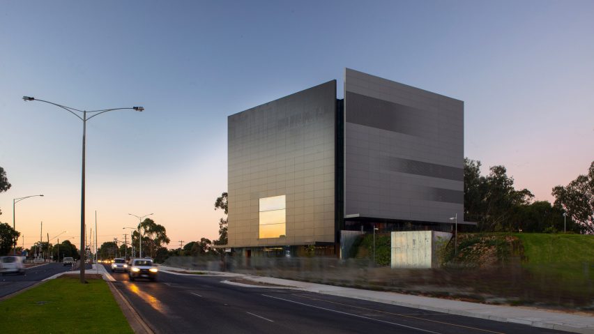 The metal facade subtlety reflects the sunset