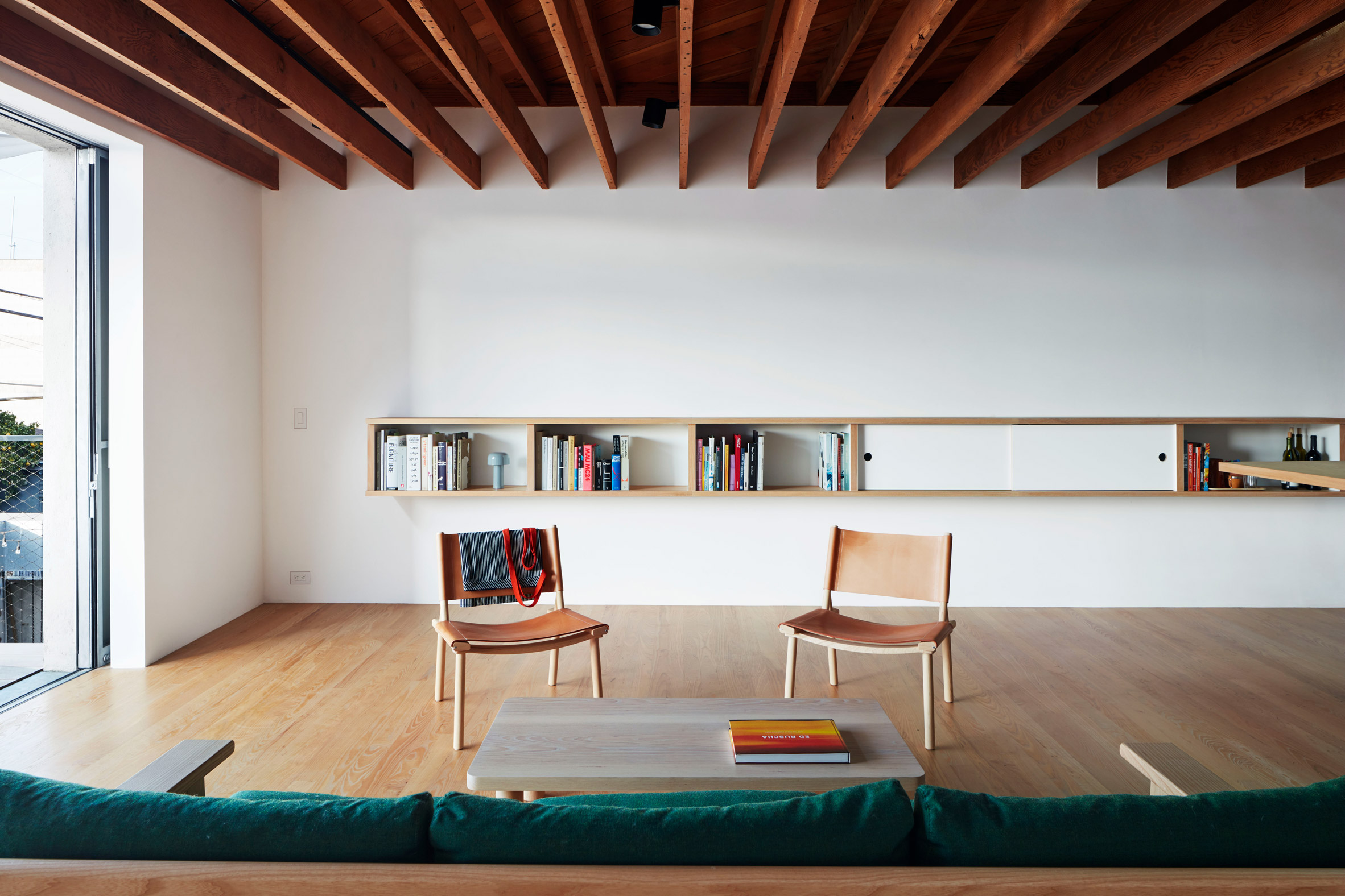 Upstairs sitting area at Emeco House by David Saik with two chairs around a coffee table and sofa 