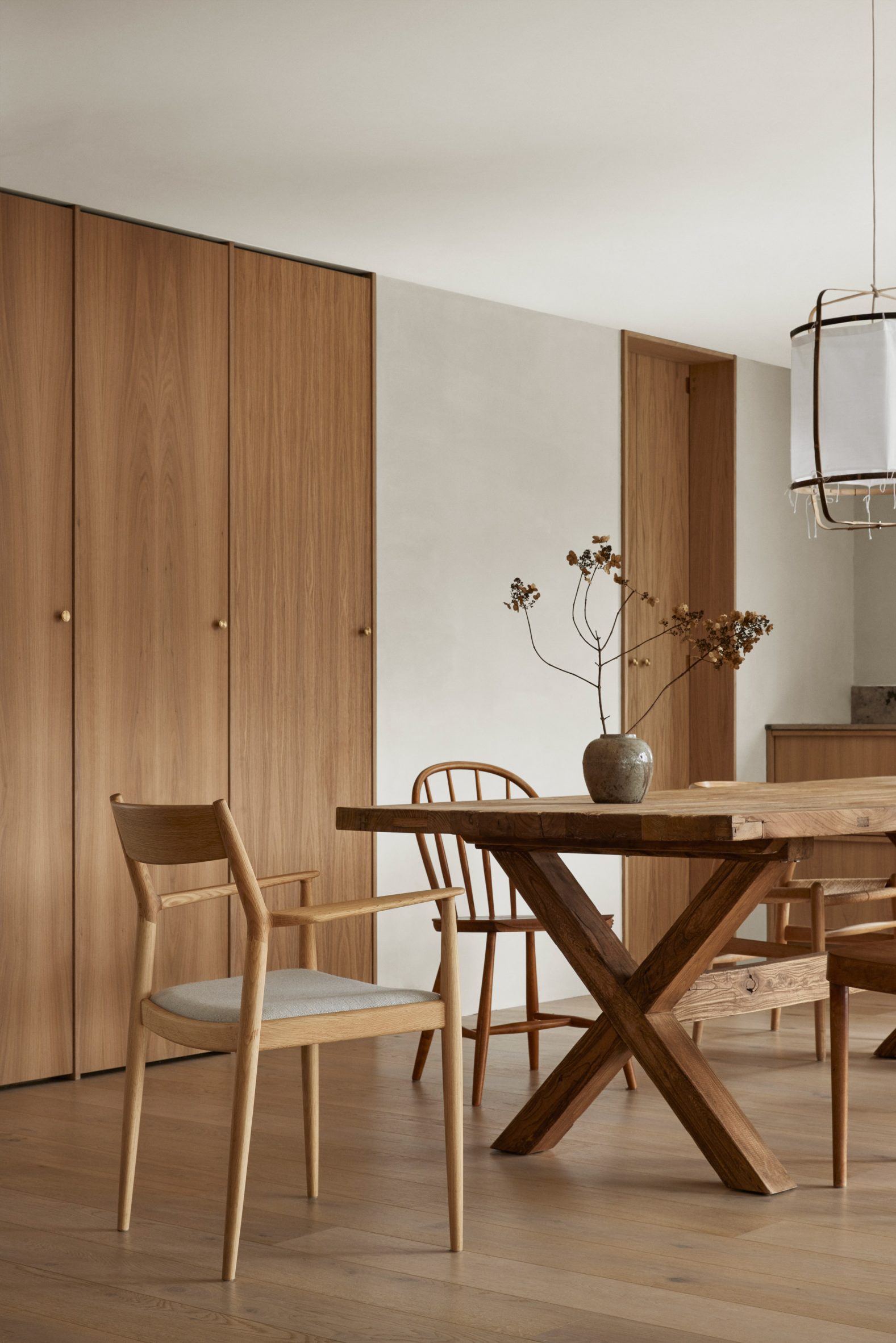 Wooden dining table and chairs in forest retreat designed by Norm Architects