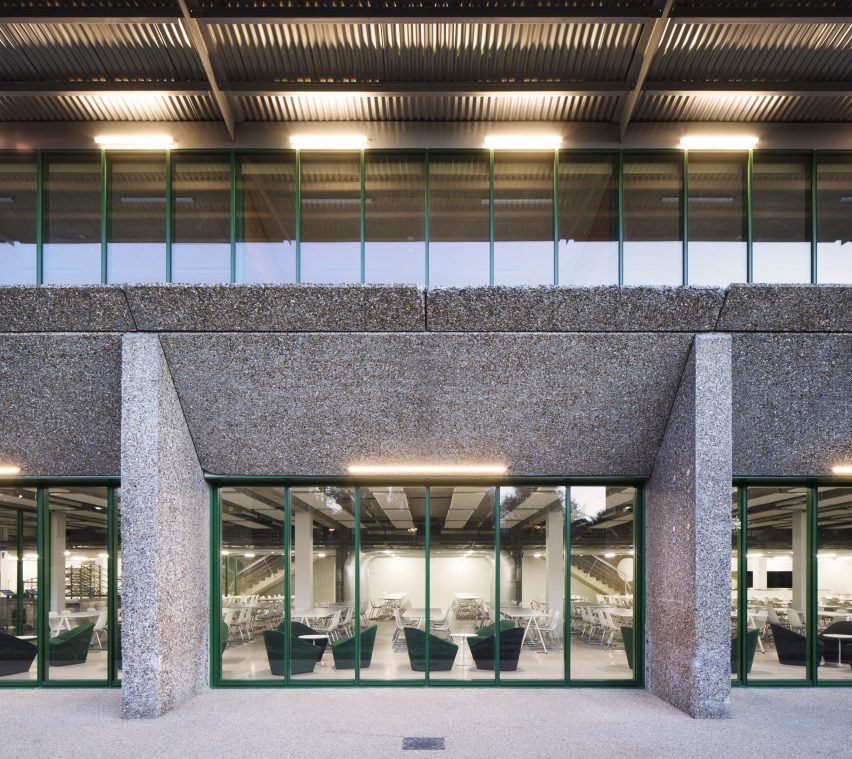 Green window frames line the openings in the concrete structure at Crous University Refectory