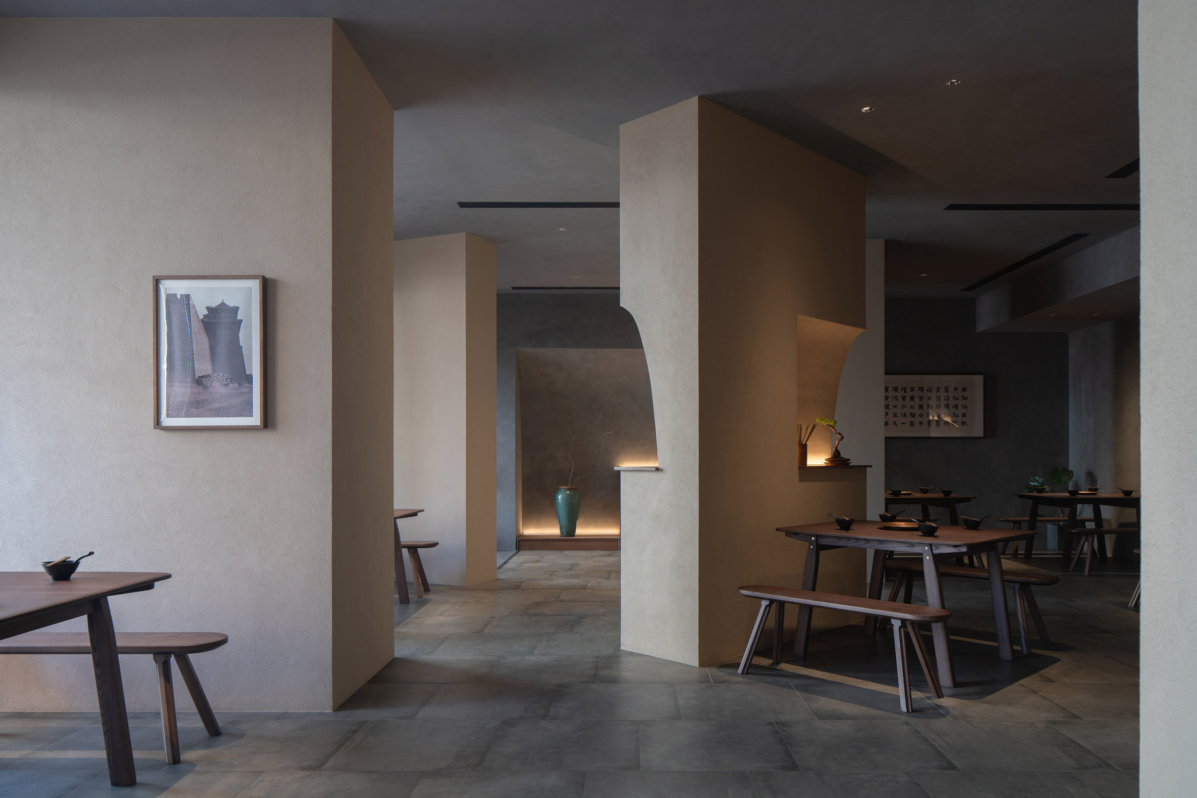 Seating nooks arranged around angled stucco walls in Jin Sheng Long restaurant
