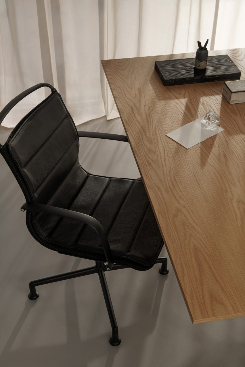 A photograph of a black office chair and desk