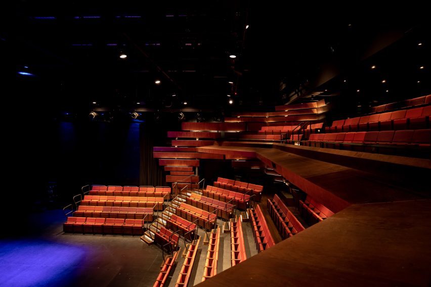 Image of a darkly lit theatre stage and seating