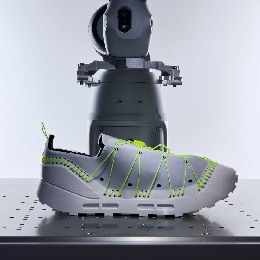 Grey trainer with fluorescent green lacing and stitches