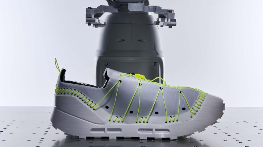 A render of a trainer with fluorescent green lacing and stitches