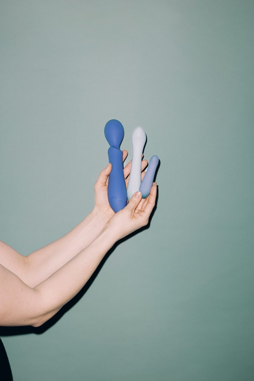 A hand holding three blue sex toys