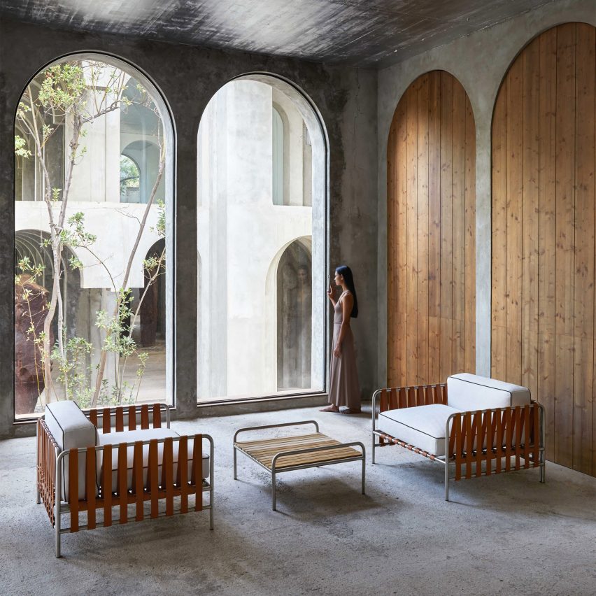 Onsen furniture collection chairs and table by Gandia Blasco used in a large concrete space in arched windows