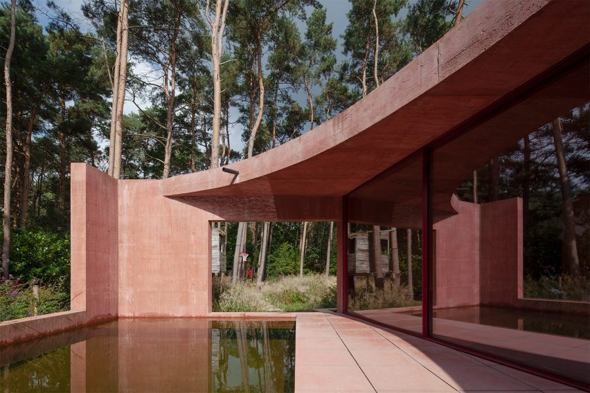 The Refuge swimming pond with curved concrete roof and cut outs in pavilion walls revealing the green landscape