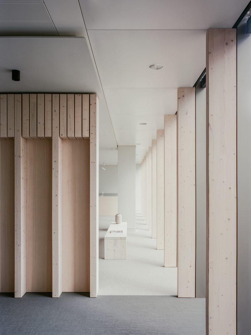Spruce wall fins and bench holding a ceramic vase in minimalist office by McLaren Excell