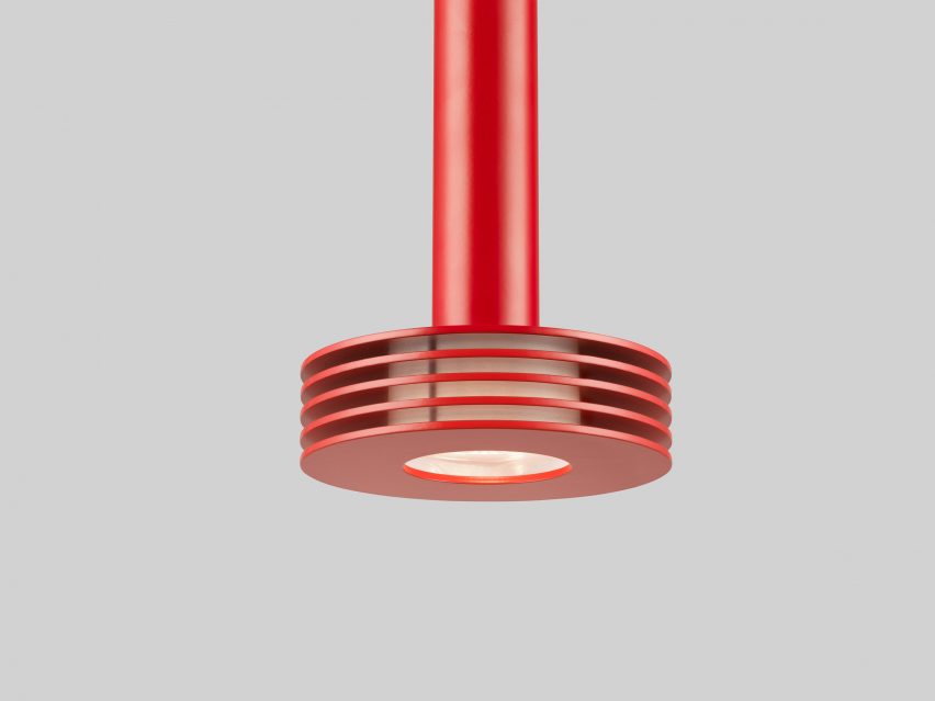 Close-up of a red pendant lamp with rings around its light source